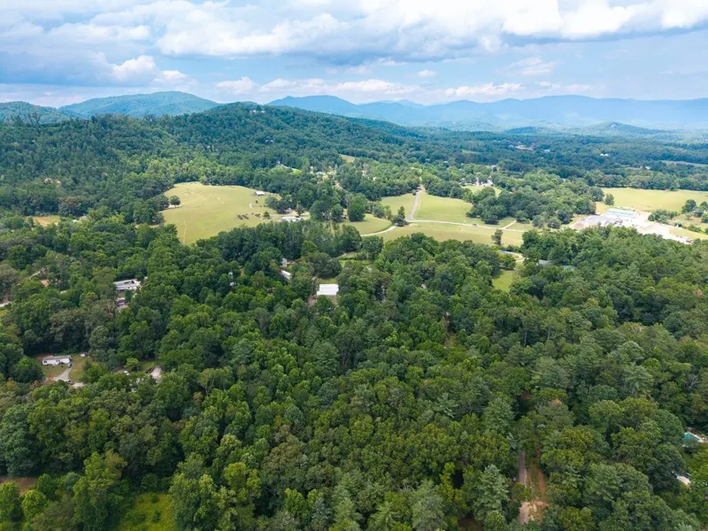 Aerial photo of wooded land, pastures and the Blue Ridge Mountains in Western North Carolina