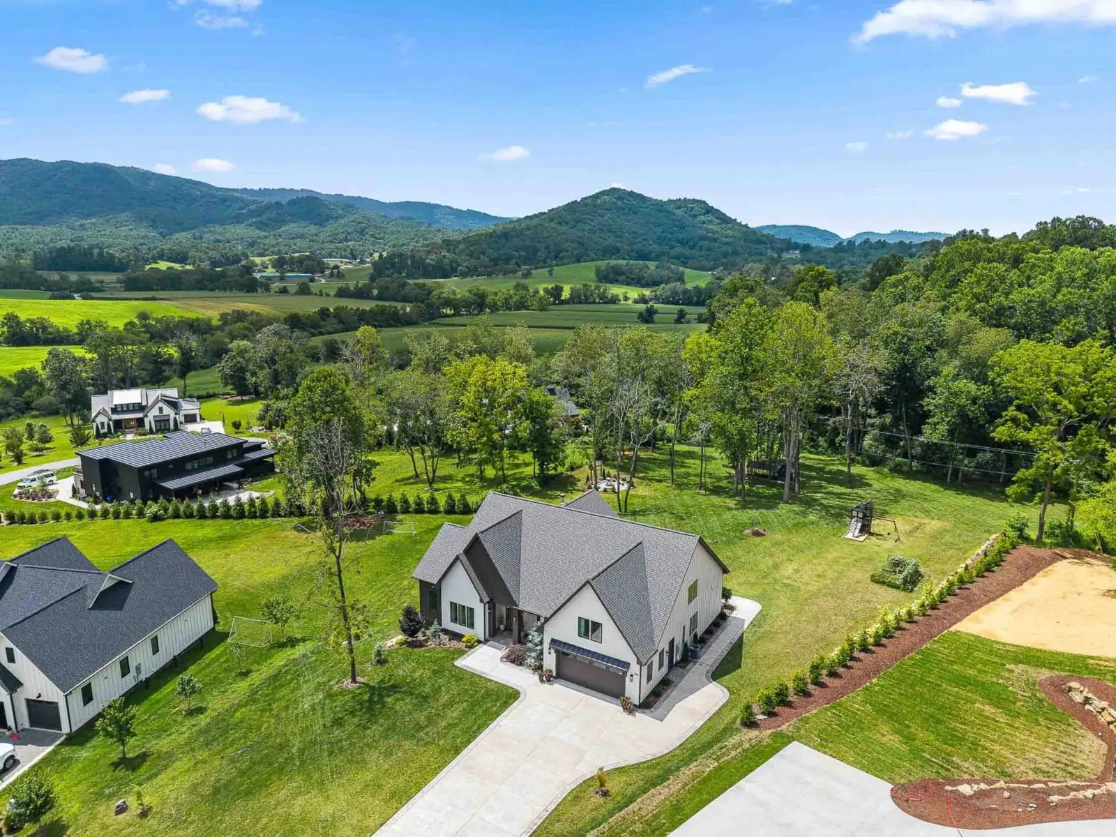 Aerial drone photo of a new farmhouse in Fairview, NC with mountain views