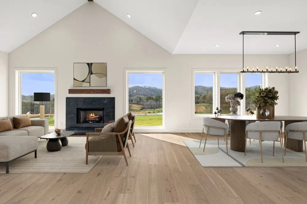 Vaulted great room with a fireplace, dining table and mountain views