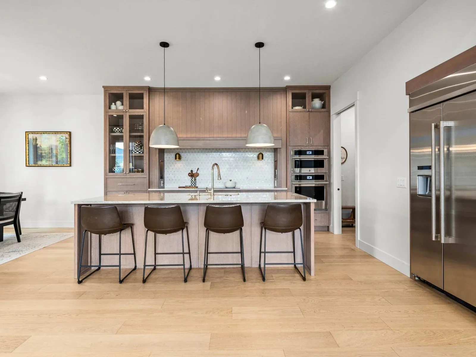 Modern kitchen with a wood island, pendant lights and stainless appliances